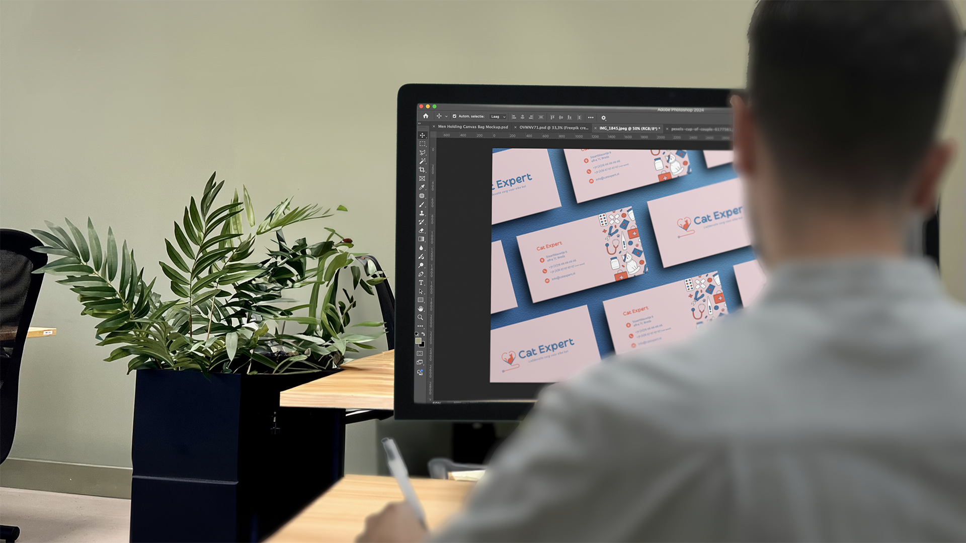 Persoon werkt aan een Cat Expert website-ontwerp op een groot beeldscherm.