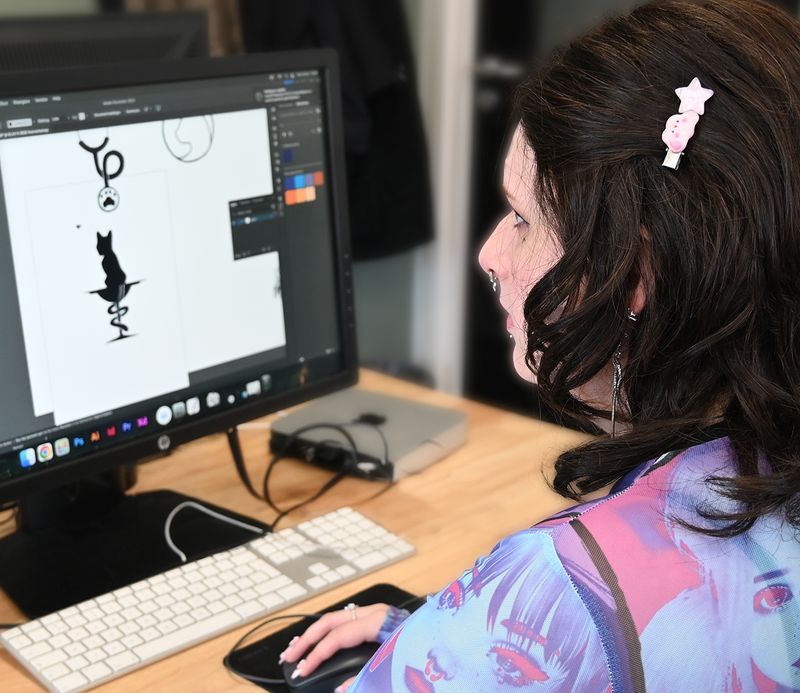 Deelneemster werkt aan een digitale illustratie achter haar computer.